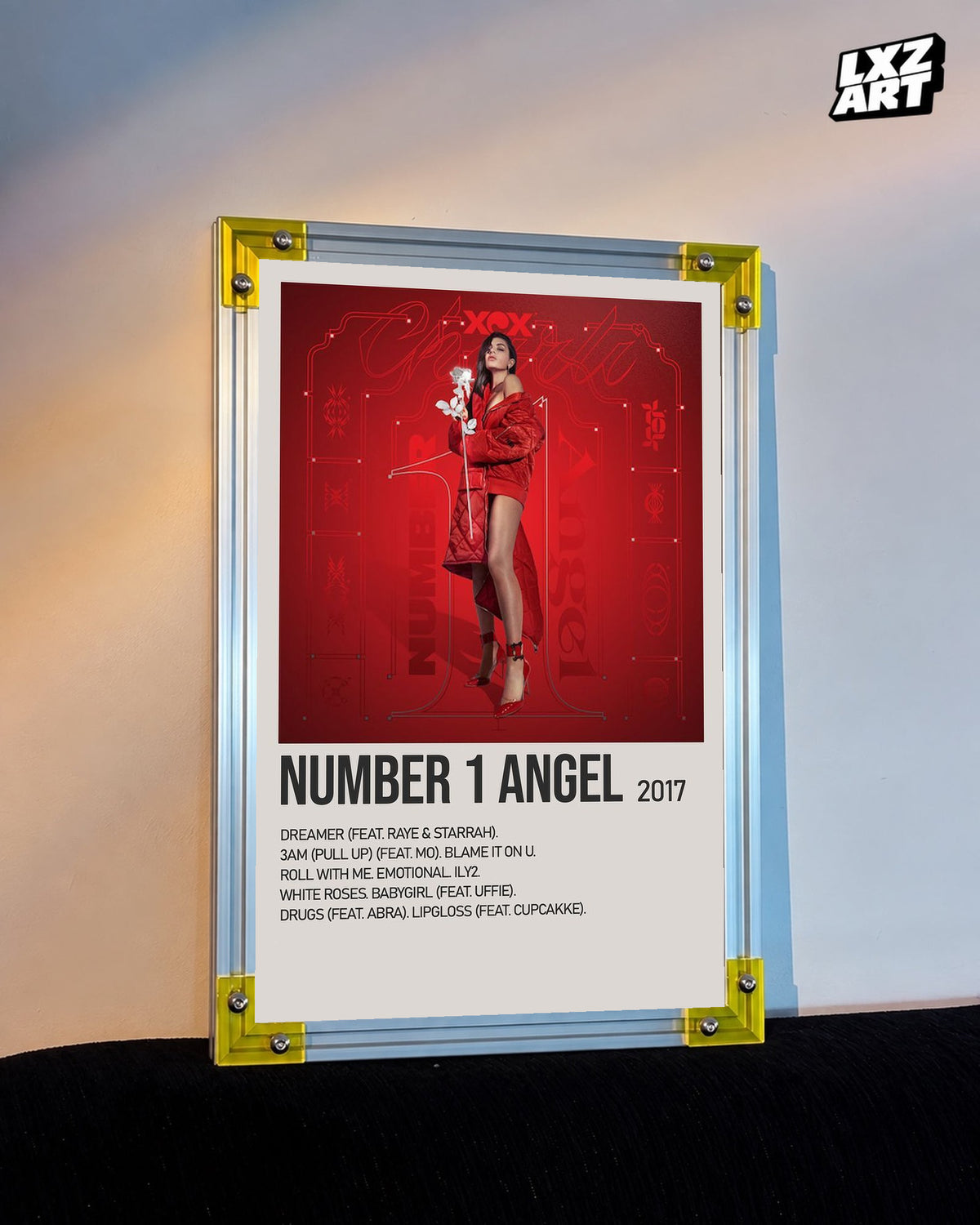 Charli xcx Number 1 Angel Red Tracklist poster displayed on a warm wall in a yellow corner frame; frame not included